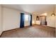 Cozy living room featuring plush carpet, large window with blue curtains, and neutral-toned walls at 17800 E Hinsdale Ave, Foxfield, CO 80016