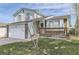 Two-story home with light-blue siding, brick accents, front porch, well-kept lawn, and an attached garage at 19485 E Purdue Pl, Aurora, CO 80013