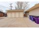 Exterior of the garage with multiple doors and ample parking space on a concrete driveway at 3127 And 3125 N Raleigh St, Denver, CO 80212