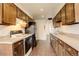 Galley kitchen featuring wood cabinets, black appliances, and neutral countertops at 3127 And 3125 N Raleigh St, Denver, CO 80212