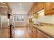 Well-lit kitchen with wooden cabinets, granite countertops, and stainless steel appliances, complemented by hardwood flooring at 3127 And 3125 N Raleigh St, Denver, CO 80212