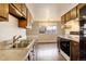 Galley kitchen with wood cabinets, neutral countertops and view of the dining area at 3127 And 3125 N Raleigh St, Denver, CO 80212