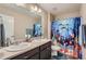 Cheerful bathroom featuring dual sinks, dark cabinets, large mirror and shower with a themed curtain at 11709 Park South Ln, Parker, CO 80138