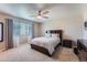 Bright bedroom features a ceiling fan, a window with blinds, and a large bed at 11709 Park South Ln, Parker, CO 80138