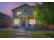 Charming two-story home featuring stone accents, a welcoming front porch, and professionally landscaped yard at dusk at 11709 Park South Ln, Parker, CO 80138