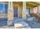 Close-up of the home's front porch featuring stone columns and cozy seating area at 11709 Park South Ln, Parker, CO 80138