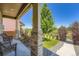 Covered porch with chairs overlooking a well-manicured lawn and garden at 11709 Park South Ln, Parker, CO 80138