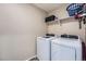 Neutral laundry room featuring a washer and dryer, and a shelf with organizers at 11709 Park South Ln, Parker, CO 80138