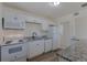 Well-lit kitchen with white appliances, white cabinets, and granite countertops at 967 Victor St, Aurora, CO 80011