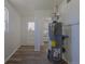 This room includes updated wood-look flooring, white walls, and new water heater at 967 Victor St, Aurora, CO 80011