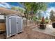 Storage shed in backyard features a small patio and mature trees at 3175 S Pennsylvania St, Englewood, CO 80113