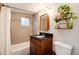 Updated bathroom boasts modern vanity, granite countertop, tile backsplash, and shower-tub combo at 3175 S Pennsylvania St, Englewood, CO 80113