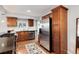 Well-lit kitchen with stainless steel appliances, dark countertops, wood floors, and light backsplash at 3175 S Pennsylvania St, Englewood, CO 80113