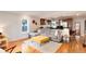 Open-concept living room and kitchen with hardwood floors, grey sofa, and ample natural light at 3175 S Pennsylvania St, Englewood, CO 80113