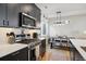 Stylish kitchen with stainless steel appliances, dark cabinetry, and a view of the dining area at 3814 Zenobia St, Denver, CO 80212