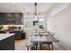Well-lit kitchen showcasing modern appliances, dark cabinetry, and a dining area with bench seating at 3814 Zenobia St, Denver, CO 80212