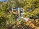 A wooded home featuring solar panels, a wooden deck, outdoor seating, and backyard recreational space at 312 Meadow View Dr, Evergreen, CO 80439