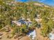 Aerial view of a mountain home with solar panels, wooded surroundings, and partial snow cover at 312 Meadow View Dr, Evergreen, CO 80439