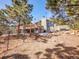 The backyard has a deck, mature trees, and some snow on a sunny day at 312 Meadow View Dr, Evergreen, CO 80439