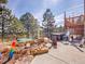 Outdoor deck with hot tub, seating, and rock landscaping with mature trees at 312 Meadow View Dr, Evergreen, CO 80439