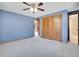 Carpeted bedroom with blue walls, featuring a spacious closet and an adjacent bathroom with glass-enclosed shower at 312 Meadow View Dr, Evergreen, CO 80439