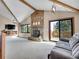 Spacious living room features vaulted ceilings, a stone fireplace, and seamless outdoor access at 312 Meadow View Dr, Evergreen, CO 80439
