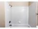Bathtub with white tiled walls and chrome fixtures, creating a clean and functional space at 5549 Helena St, Denver, CO 80239