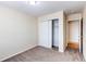 Bedroom featuring neutral paint and carpet, a closet, and an en suite bathroom at 5549 Helena St, Denver, CO 80239