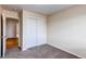 Bedroom featuring neutral paint and carpet, closet, and doorway to additional rooms at 5549 Helena St, Denver, CO 80239