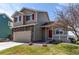 Charming two-story home featuring stone accents, a well-manicured lawn, and a welcoming front porch at 5549 Helena St, Denver, CO 80239