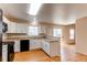 Bright kitchen featuring white cabinets, wood floors, and modern appliances at 5549 Helena St, Denver, CO 80239