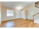 Bright living room featuring wood-look floors, a staircase, multiple closets, and a window for natural light at 5549 Helena St, Denver, CO 80239