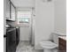 Well-lit bathroom and laundry room with stylish tile flooring, modern washer and dryer, and a toilet at 690 S Newark Ct, Aurora, CO 80012