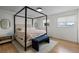 Stylish bedroom with a modern four-poster bed frame, neutral tones and hardwood flooring at 690 S Newark Ct, Aurora, CO 80012