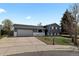 Exterior view of home features a driveway, well-maintained lawn, mature trees, and a convenient two-car garage at 690 S Newark Ct, Aurora, CO 80012
