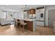 Open-concept kitchen with island seating, modern lighting, and seamless flow to the living area at 690 S Newark Ct, Aurora, CO 80012