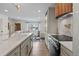 Modern kitchen with a central island, sleek appliances, and seamless transition to the living space at 690 S Newark Ct, Aurora, CO 80012