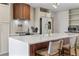 Close up of the bright kitchen island, showcasing a waterfall countertop and wood accents at 690 S Newark Ct, Aurora, CO 80012