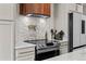 The kitchen showcases a modern cooktop with a decorative backsplash and pot filler faucet at 690 S Newark Ct, Aurora, CO 80012