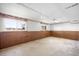 Finished basement with carpet and wood paneling, featuring two bright windows at 12940 W 75Th Ave, Arvada, CO 80005
