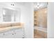 Bright bathroom with a sink, vanity, mirror, and a tiled shower/tub combo at 12940 W 75Th Ave, Arvada, CO 80005