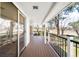Covered outdoor deck with wood flooring and iron railing, offering scenic views at 12940 W 75Th Ave, Arvada, CO 80005