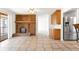 Spacious living room with a brick fireplace and stainless steel refrigerator at 12940 W 75Th Ave, Arvada, CO 80005