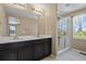 Bathroom featuring double vanity, walk-in shower with window and tiled floors at 6404 Dry Fork Dr, Frederick, CO 80516