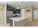 Open-concept kitchen with stainless steel appliances, an island, and dark wood cabinetry at 6404 Dry Fork Dr, Frederick, CO 80516