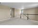 Carpeted second floor landing with multiple doorways and a window at 6404 Dry Fork Dr, Frederick, CO 80516
