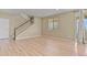 Spacious living area with light wood floors, a staircase, bright window, and sliding doors at 6404 Dry Fork Dr, Frederick, CO 80516