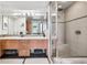 Bathroom featuring double sink vanity, tiled shower, and neutral color palette, providing a calming and functional space at 1401 Wewatta St # 911, Denver, CO 80202