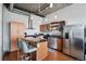 Kitchen with stainless steel appliances, wooden cabinets and an island with bar seating at 1401 Wewatta St # 911, Denver, CO 80202