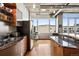 Contemporary kitchen featuring stainless steel appliances, granite counters, breakfast bar, and hardwood floors at 1401 Wewatta St # 911, Denver, CO 80202